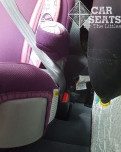 Booster seat buckle access is important! Side view of seat belt buckled over purple booster seat.