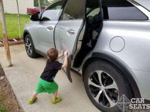 Lock before you leave! Young child closing door of grey minivan