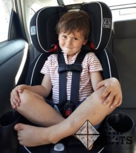 four year old sitting cross legged in Graco Nautilus Snuglock
